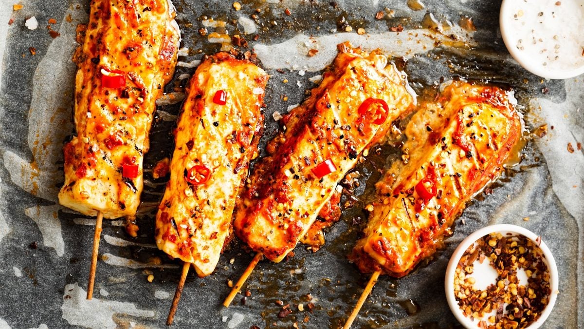 Sweet Chili Halloumi Spieße auf einem Backblech mit Backpapier.