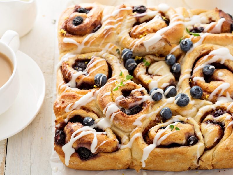 Draufsicht auf schwedische Blaubeerschnecken mit dem Frischkäse-Frosting.