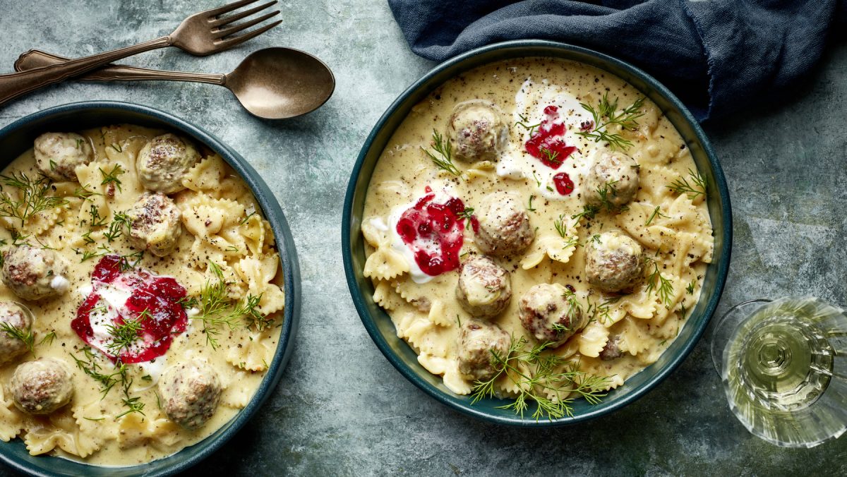 Draufsicht: Zwei tiefe Teller mit One-Pot-Pasta Köttbullarstyle auf grauem Untergrund.