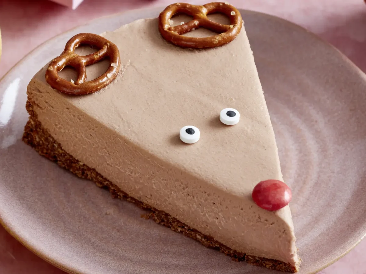 Rudolph-Cheesecake auf einem rosa Teller auf rosa Hintergrund.