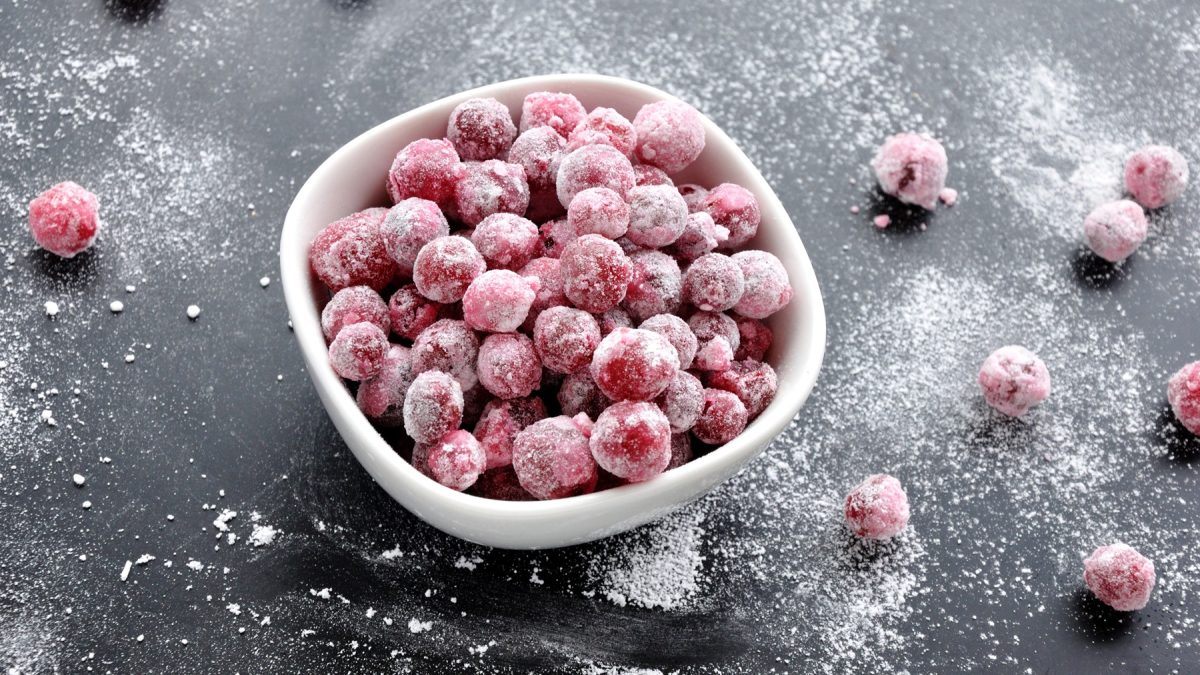 Eine weiße Schale mit den Cranberry Pops auf schwarzem Untergrund. Alles von schräg oben fotografiert.