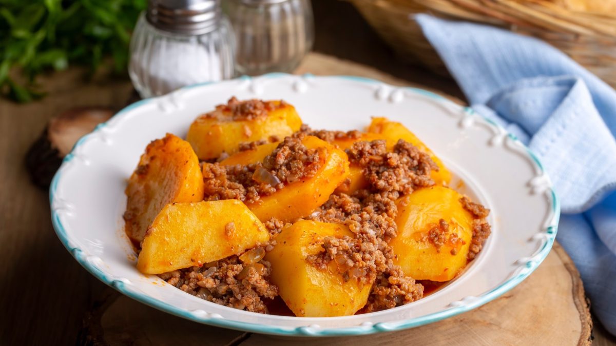 Frontal: Eine heller Teller auf dem gekochtes Hackfleisch und gegarte Kartoffeln liegen. Es handelt sich um das türkische Gericht Kiymali Patates.
