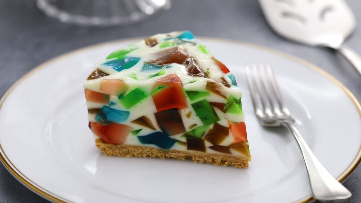 Ein Stück Terrazzo Kuchen auf einem weißen Teller mit goldenem Rand. Alles auf einem grauen Tisch mit silberner Gabel.