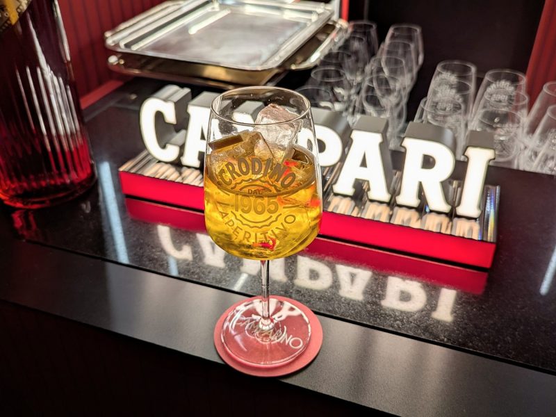 Der Crodino Spritz an der Campari-Bar mit leuchtendem Logo im Hintergrund.