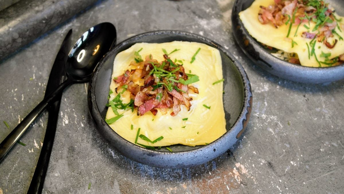 Zwei graue Schälchen mit den Ravioli auf einem Steintisch von schräg oben fotografiert.