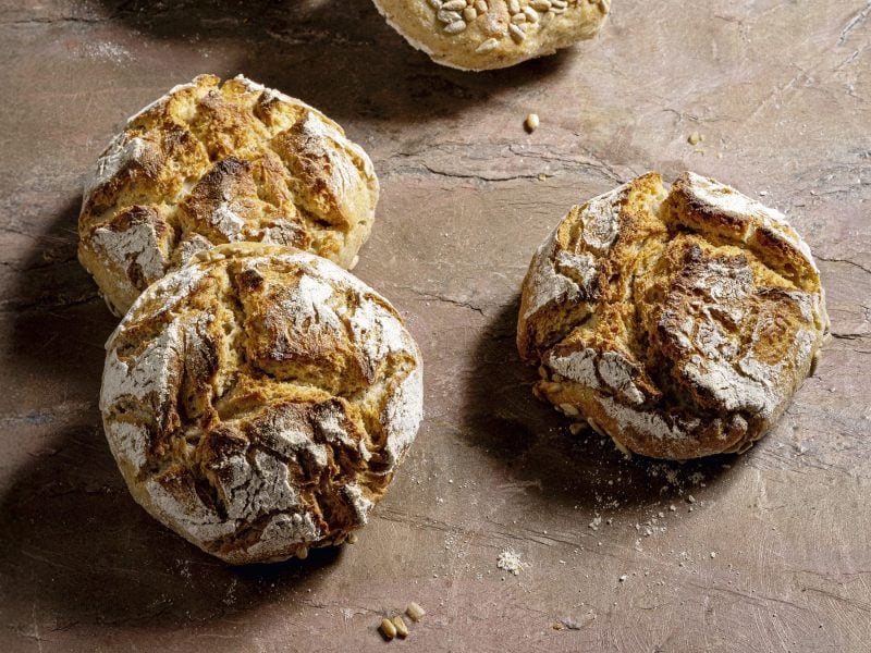 Mehrere Brötchen auf einem Holztisch direkt von oben fotografiert.