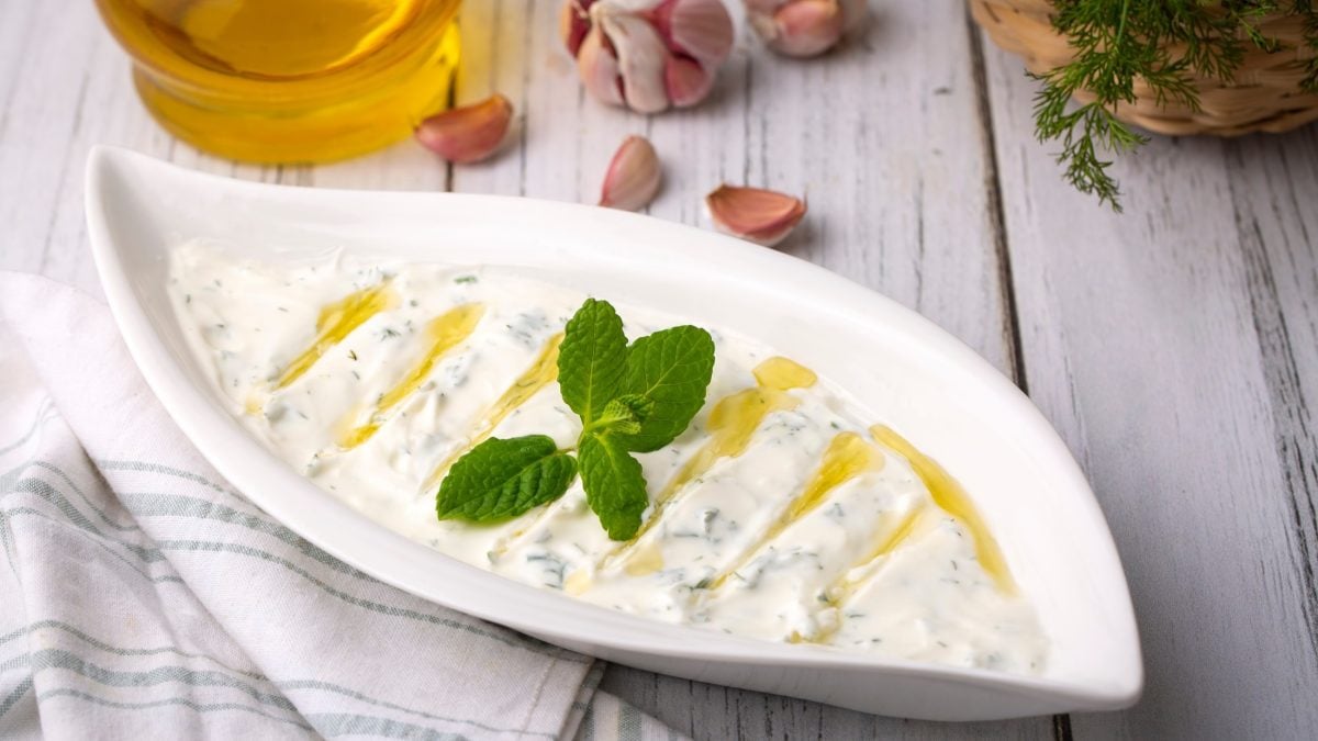 Draufsicht: Helle Form mit dem türkischen Joghurt-Dip Haydari auf einem Tisch.