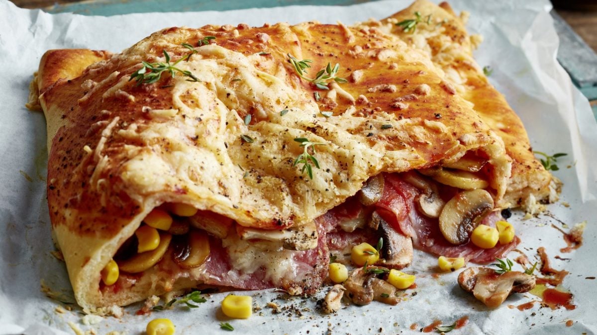 Pizza Calzone aus weißem Backpapier.
