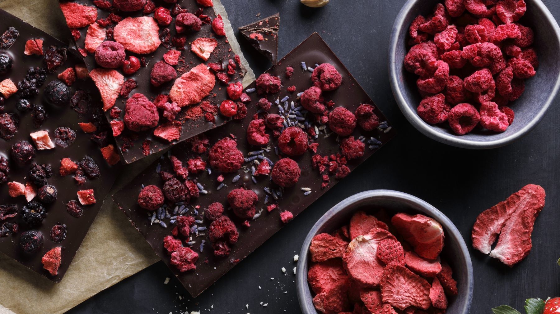 Selbstgemachte Erdbeer-Erdnussbutter-Schokolade in Stücke gebrochen, mit sichtbaren Schichten aus dunkler Schokolade, cremiger Erdnussbutter und knusprigen, gefriergetrockneten Erdbeeren als Topping.