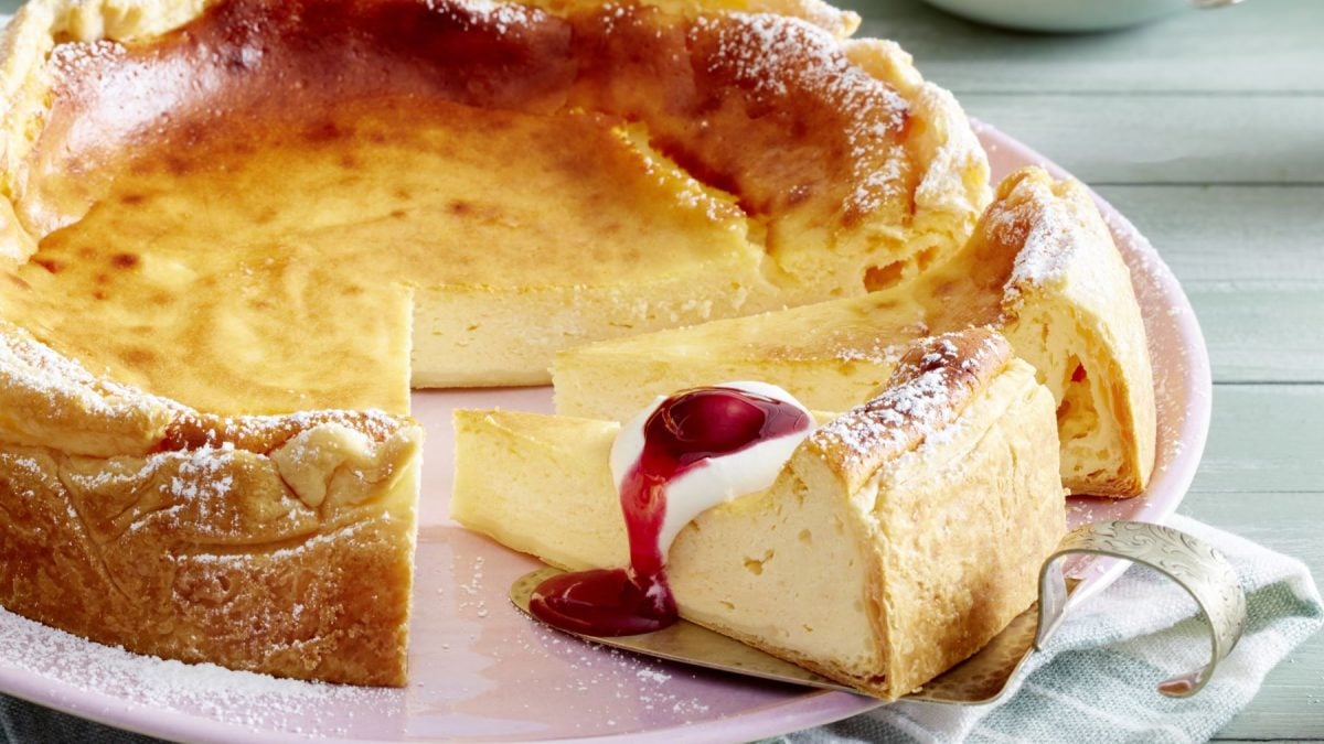 Ratzfatz-Cheesecake auf einem rosa Teller vor grauem Hintergrund.