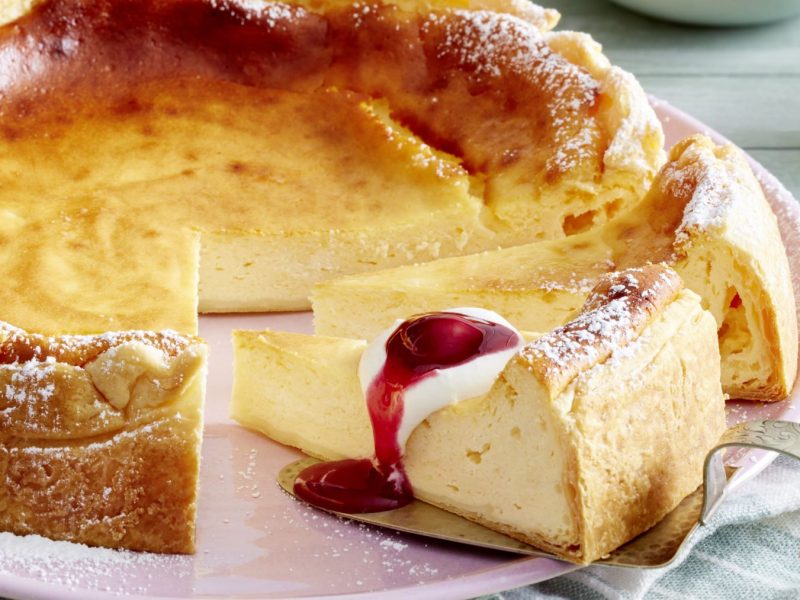 Ratzfatz-Cheesecake auf einem rosa Teller vor grauem Hintergrund.