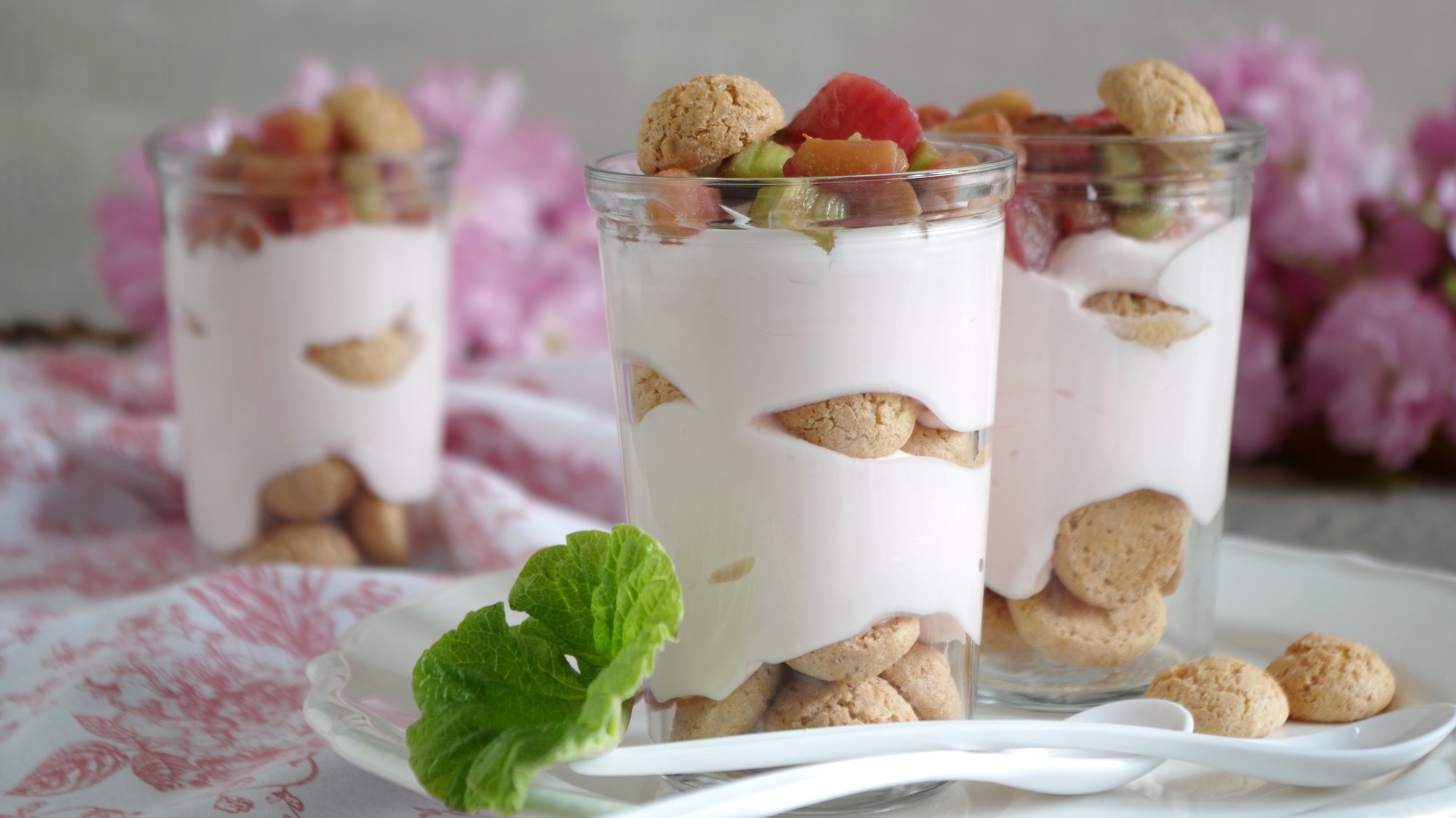 Rhabarber-Quark-Dessert mit Amaretti in Dessertglas geschichtet.