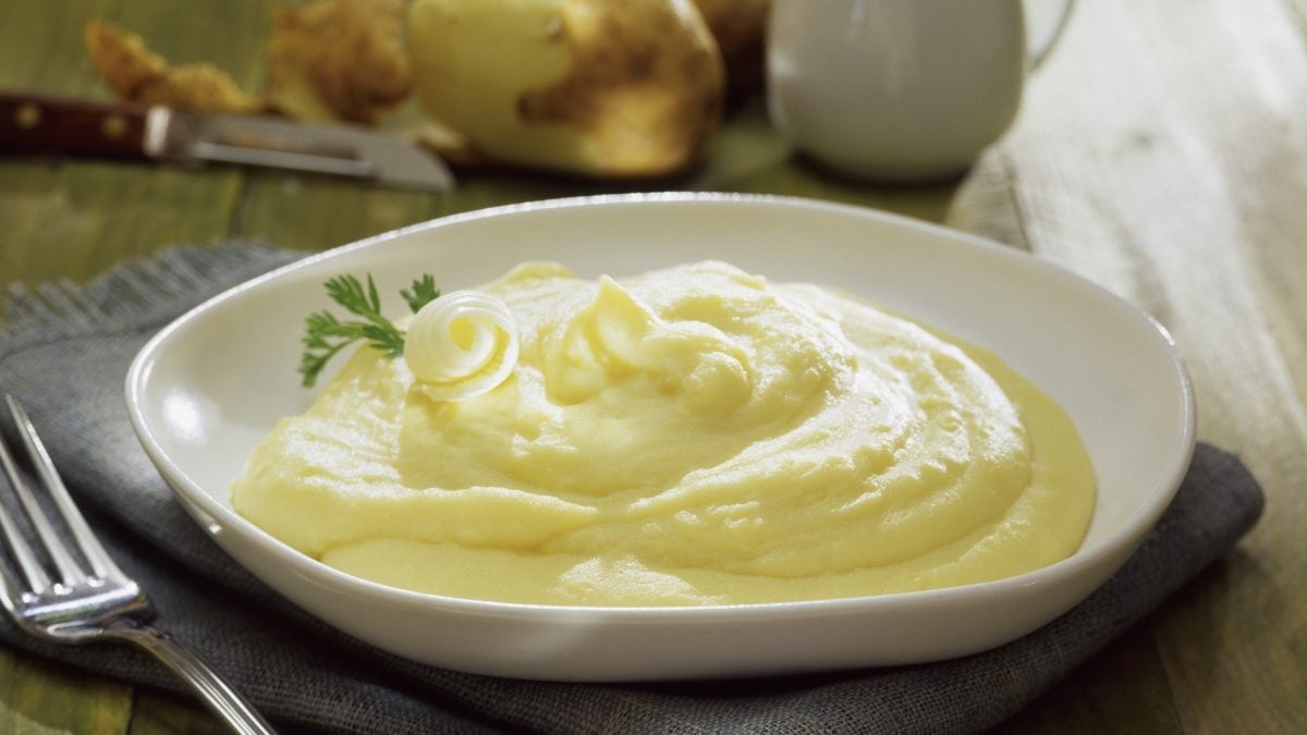 Eine Kartoffel-Mousseline in einem weißen Teller / Gabel / Frontalsicht