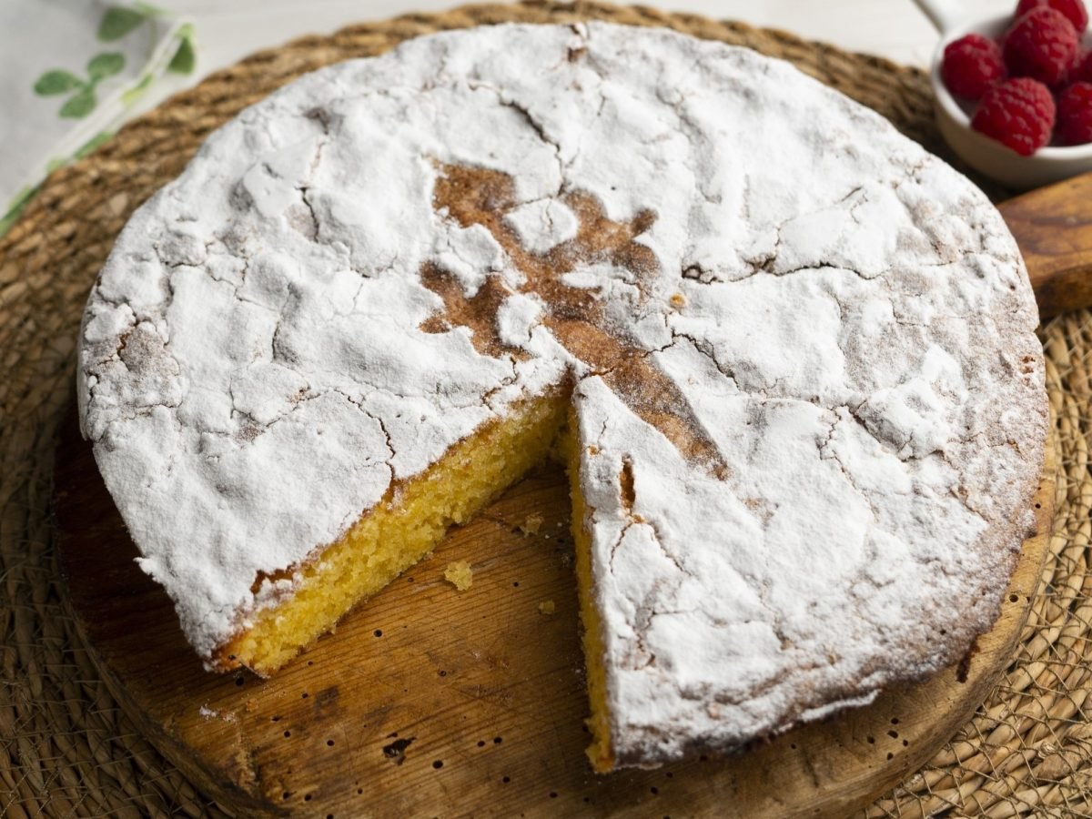 Eine angeschnittene Tarta de Santiago / bast-Unterlage / Draufsicht leicht schräg