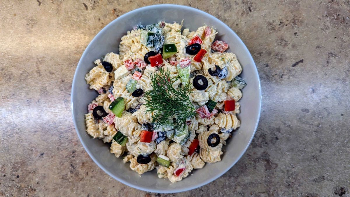 Schale mit Tzatziki-Nudelsalat auf Marmorplatte.
