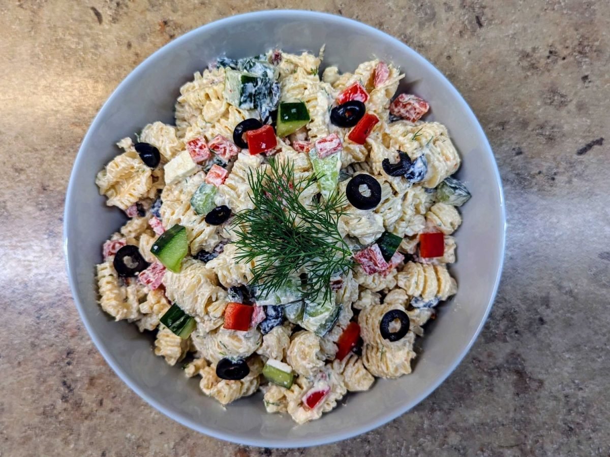 Schale mit Tzatziki-Nudelsalat auf Marmorplatte.